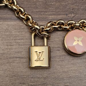 Close up of the mini LV padlock and a pink enamel flower charm