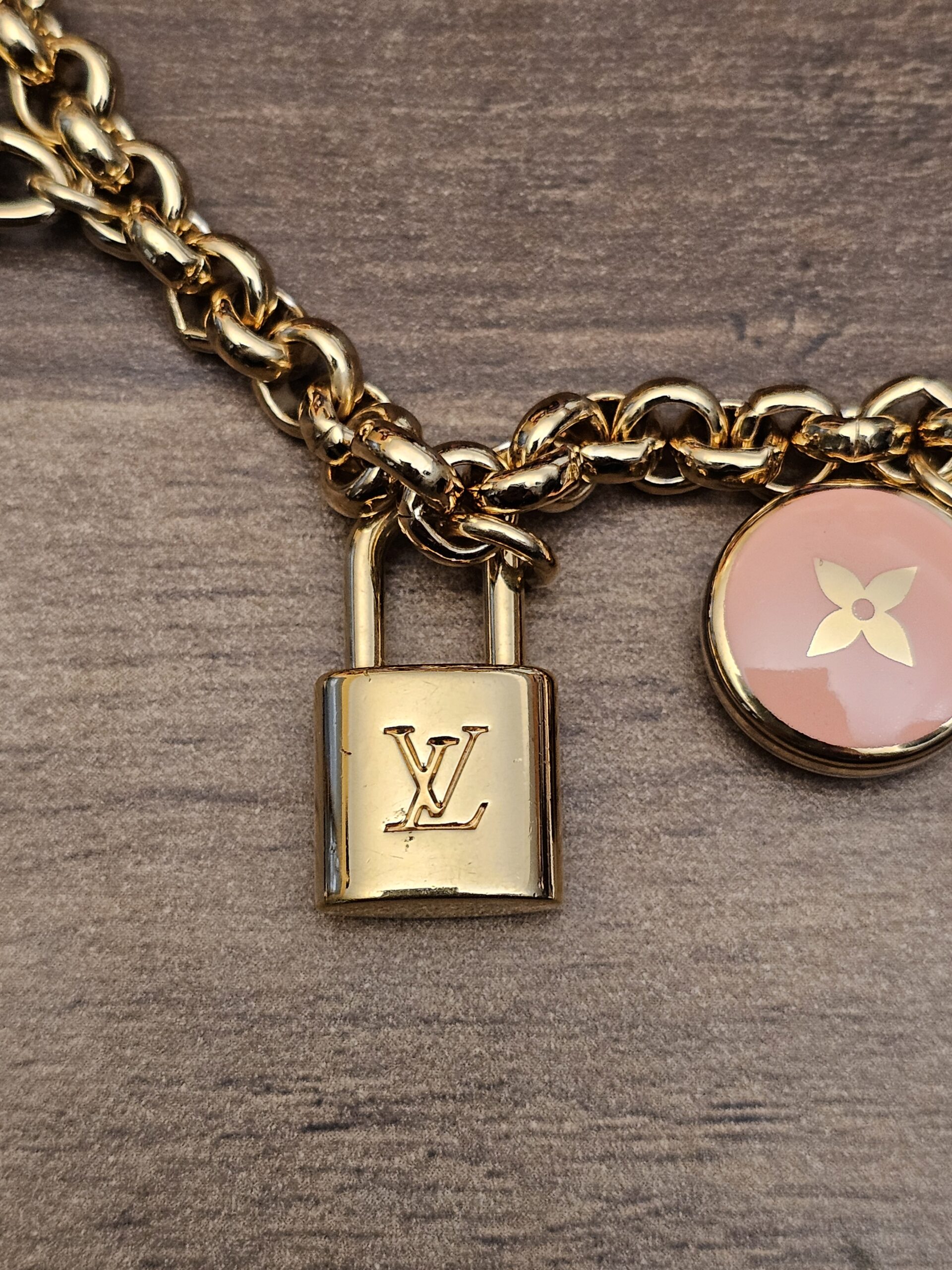 Close up of the mini LV padlock and a pink enamel flower charm