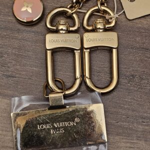 Two engraved lobster clasps and the logo plate in its protective film