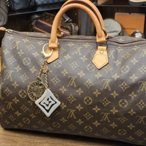 The charm on a Monogram canvas bag for scale