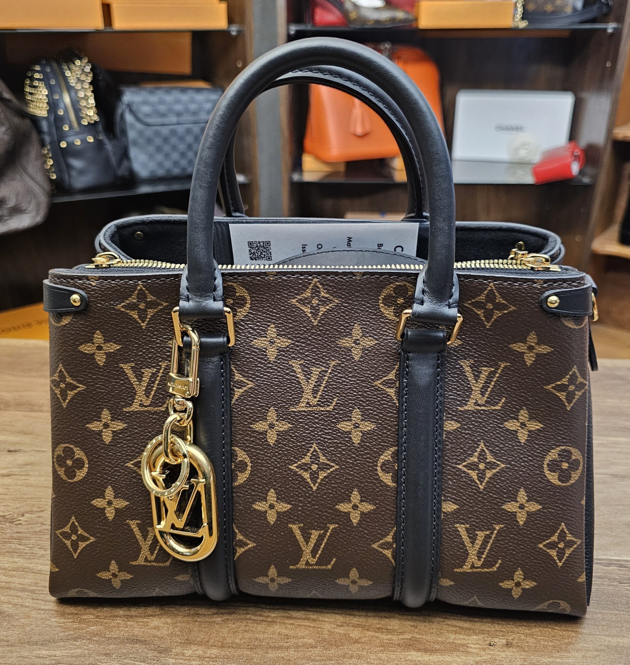 The charm on a Monogram canvas bag for scale