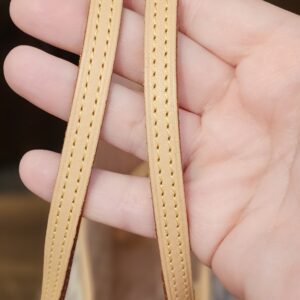 Vachetta shoulder straps held in hand