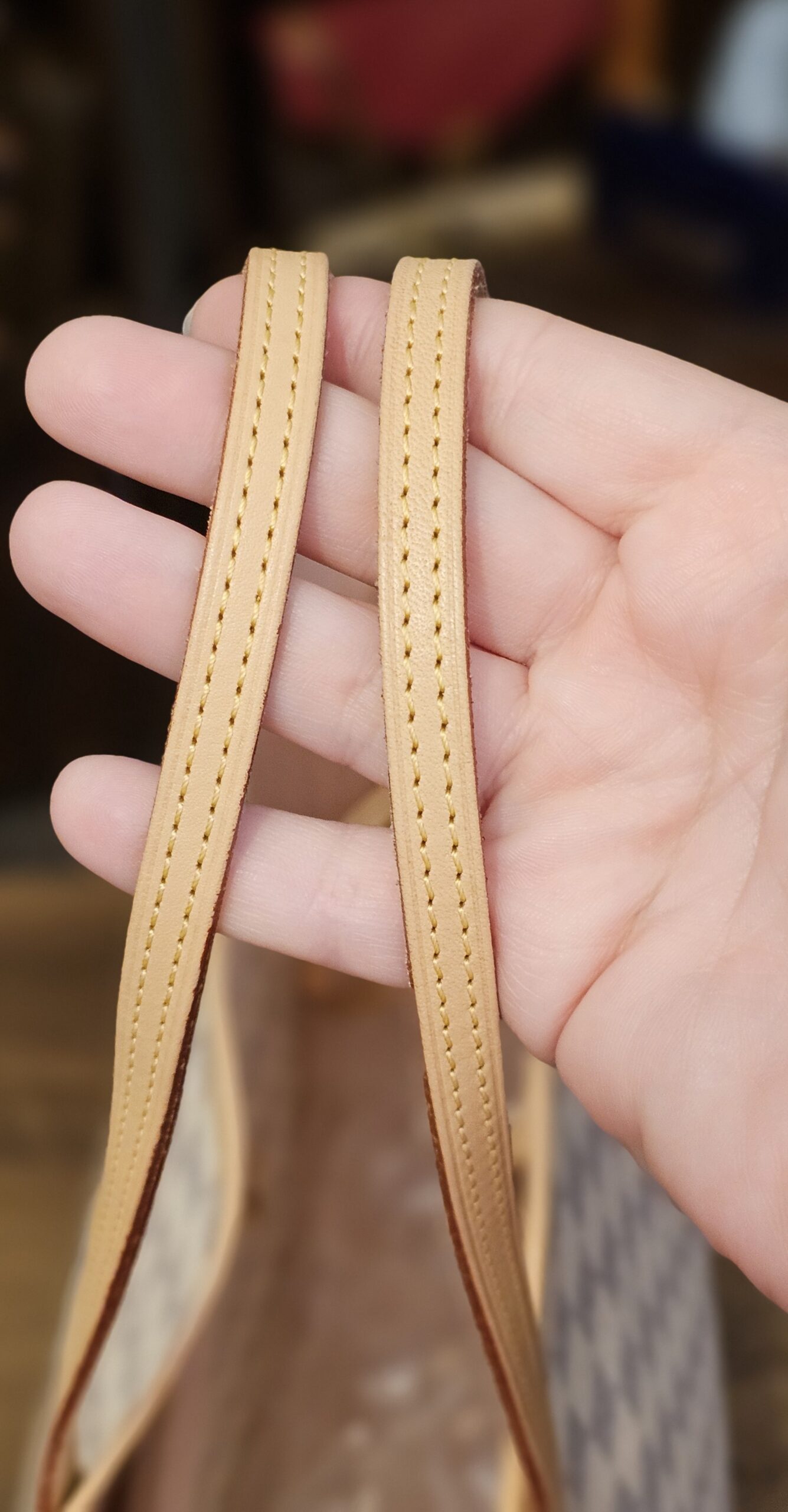 Vachetta shoulder straps held in hand