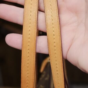 Vachetta shoulder strap held in hand