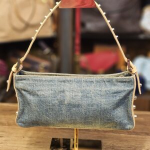 The bag, front view on a stand with the studded shoulder strap