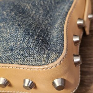 Close up of a studded corner and the distressed denim