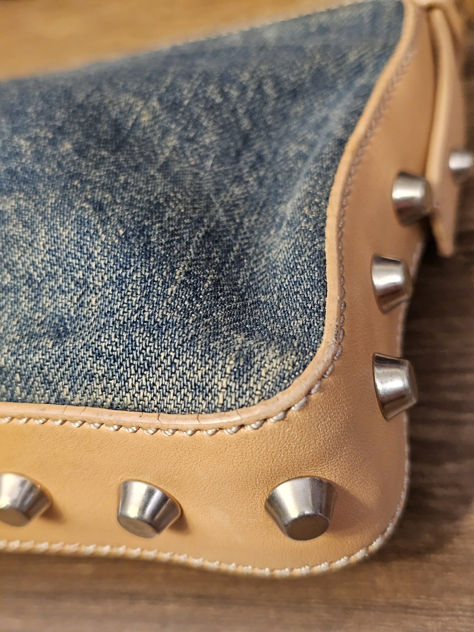Close up of a studded corner and the distressed denim