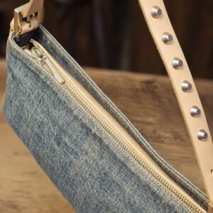 Side view with the zip top and studded strap